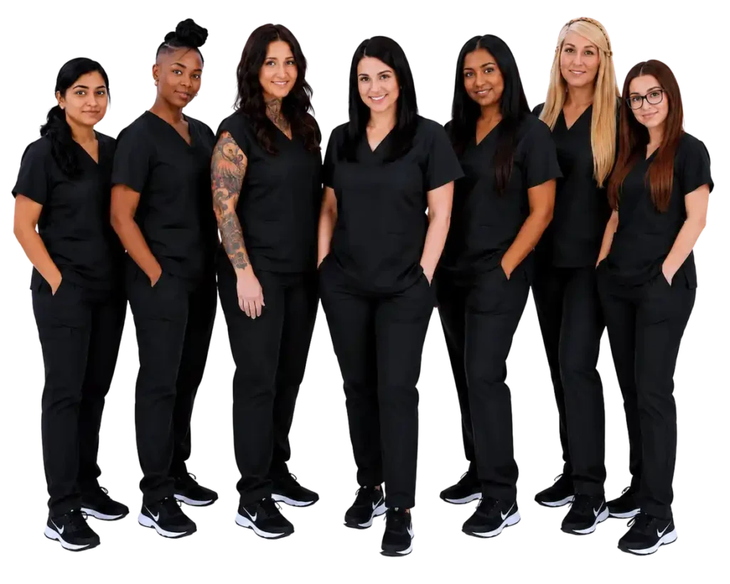 Seven women in black scrubs standing together, showcasing diverse healthcare team.