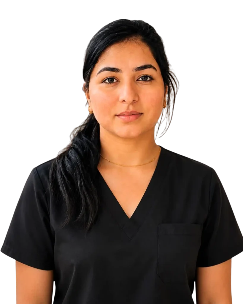 Woman in black scrubs with a serious expression against a black background, representing healthcare professional.